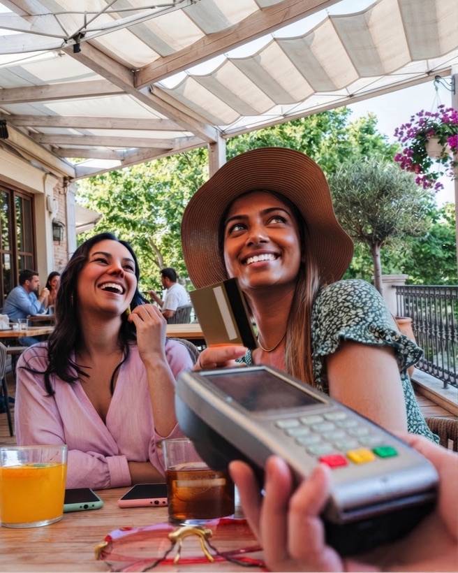 Friends paying with a card at a caf&eacute;